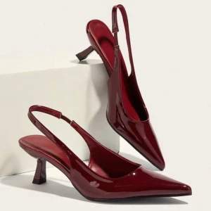 Vinröda pumps med slingback - Eleganta vinröda pumps med spetsig tå. Skorna har en glansig finish och en smal klack. Köpte skorna på shein för 230kr förra veckan men råkade köpa fel storlek där av säljer jag. Dem är endast prövade en gång! 