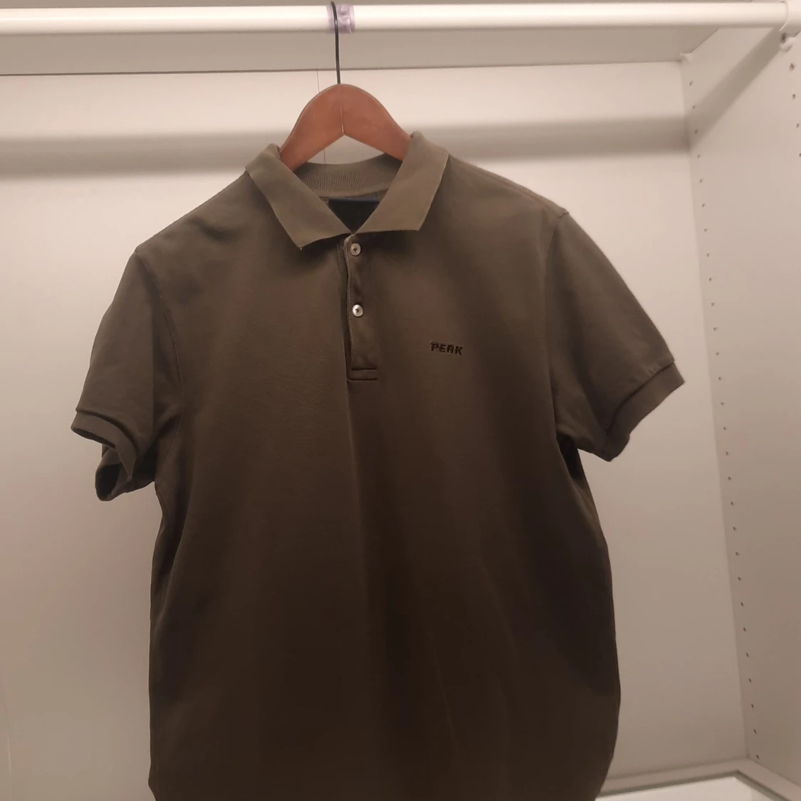 Olivgrön pikétröja från Peak Performance