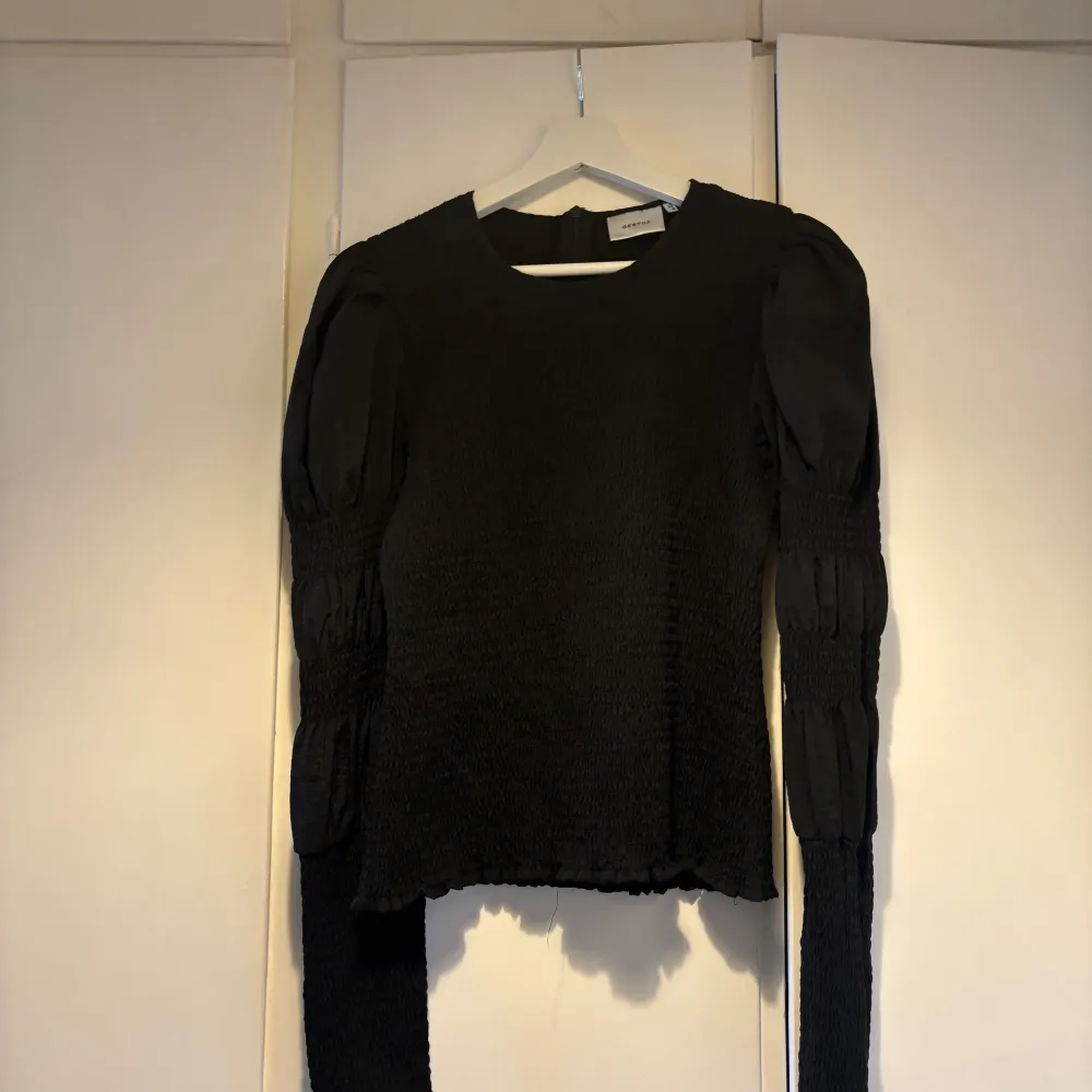 Snygg svart blus från Gestuz med långärmade puffärmar och en smockad textur. I storlek 40, tycker den passar snyggt på mig som är en strl 36 men det är en smaksak. . Puserot.