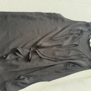 Svart klänning från Zara Trafaluc - Elegant svart klänning från Zara Trafaluc i en stilren design. Klänningen har en enkel och klassisk look med en normal passform. Perfekt för olika tillfällen och lätt att matcha med accessoarer.