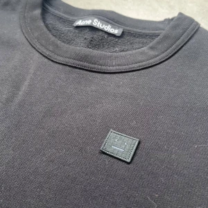 Acne Studios Svart tröja  - Säljer en stilren svart tröja från Acne Studios.  Tröjan har en rund halsringning och en diskret logotyp på bröstet. Perfekt för en minimalistisk look. Köpt för drygt ett år sedan på Vallgatan 12 i Gbg. Inköpt för ca 2800kr. 