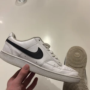 Vita Nike sneakers Court Vision - Snygga vita Nike sneakers med klassisk svart swoosh. Skorna har snörning och en bekväm sula med bra grepp. Perfekta för en avslappnad stil.