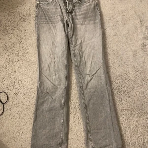 Grå jeansbyxor - Snygga grå jeansbyxor med en klassisk design. De har en rak passform och är perfekta för en avslappnad stil. Byxorna har fickor både fram och bak samt en knapp- och dragkedjestängning.