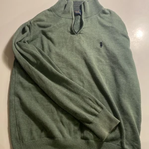 Grön tröja från Polo Ralph Lauren - Snygg grön tröja från Polo Ralph Lauren. Den har ingen dragkedja men det ser inte alls konstigt ut