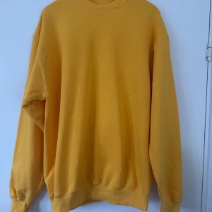 Gul sweatshirt från Fruit of the Loom - Säljer en klassisk gul sweatshirt från Fruit of the Loom. Tröjan har långa ärmar och en rund halsringning. Perfekt för en avslappnad stil. Passar bra till både jeans och mjukisbyxor. 🍋