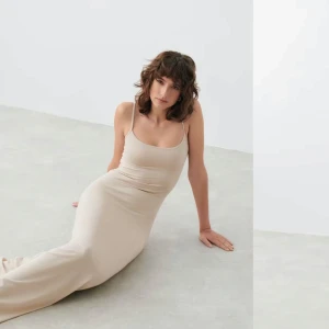 Beige maxi slip dress från Gina Tricot - Soft touch ärmlös långklänning i trikå med tunna axelband. Klänningen är brun och har figurnära passform med lätt utsvängd kjol.