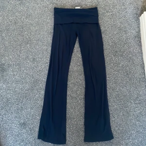 Mörkblåa yoga pants - Snygga mörkblå byxor från Gina Tricot med en bekväm passform. Byxorna har en midja man kan vika ner och är tillverkade i ett mjukt material som ger en skön känsla. Perfekta för en avslappnad stil.