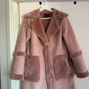 Rosa teddyjacka från Stradivarius - Mysig rosa teddyjacka från Stradivarius med dragkedja och stora fickor. Jackan har en klassisk krage och långa ärmar, perfekt för kyligare dagar. Den är både stilren och bekväm, vilket gör den till ett måste i garderoben.