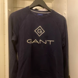 GANT tröja storlek 170 cm - Säljer en stilren mörkblå tröja från GANT. Org pris ca 1000 kr, men säljer för mindre än hälften av org pris. Använd men i väldigt bra skick.