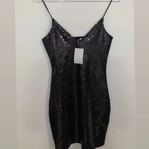 Svart glittrig klänning med smala axelband - Black glittery dress from H & M brand in the size S completely new with the tags on