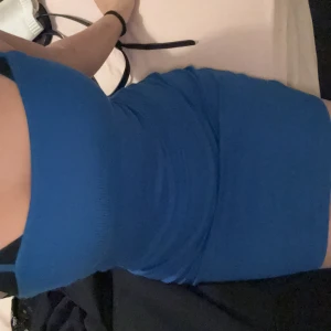 Blå tight klänning - Snygg blå tight klänning med smala axelband. Perfekt för en kväll ute eller en speciell tillställning. Klänningen har en enkel och stilren design som framhäver figuren.