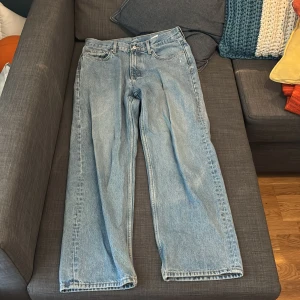 Blå jeans från Weekday - Säljer ett par blå jeans från Weekday i modellen Galaxy. De har en loose straight passform och är tillverkade i denim. Perfekta för en avslappnad stil. Bra skick, inga defekter. Storlek 30/32