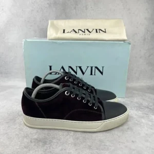 Svarta sneakers från Lanvin - Snygga svarta sneakers från Lanvin med snörning och en stilren design. Skorna har en svart ovandel i mocka och en tå i glansigt material. Sulan är vit och ger en fin kontrast till den mörka ovandelen.