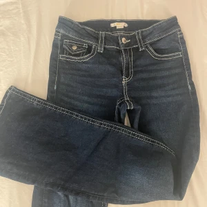 Mörkblå jeans från Gina Tricot - Snygga mörkblå jeans som är bootcut och low waist från Gina Tricot young i storlek 164. Jag är 160cm och de är lite långa för mig. Jeansen är knappt använda och i bra skick!💗