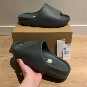 Yeezy Slides - Hej, jag säljer ett par Adidas YZY Slide i färgen svart. De är helt nya och köpta från adidas CONFIRMED. Har online kvitto 🧾 från appen, bara att höra av sig om man har någon fråga.