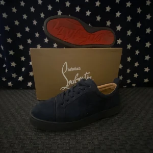 Blå sneakers från Christian Louboutin - Snygga blå sneakers från Christian Louboutin med den ikoniska röda sulan. Skorna har en stilren design med snörning och är tillverkade i ett mjukt material som ger en lyxig känsla.Inte alls slitna.Köpt för 6800:Kan sänka priset vid snabb affär 