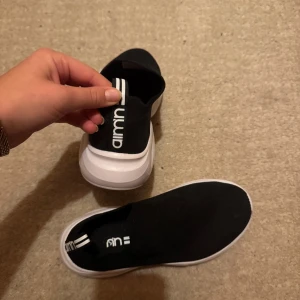 Träningsskor  - Säljer ett par svarta sneakers från Aimn med vit sula. Använda 1 gång, så gott som nya.  Skorna har en enkel och stilren design med elastisk passform för enkel på- och avtagning. Perfekta för en avslappnad stil.