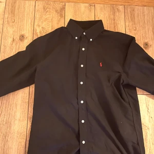 Svart Ralph lauren skjorta - Svart skjorta ifrån Ralph lauren i storlek smal den är i bra skick 