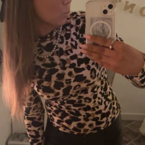 Leopardmönstrad polotröja från Gina Tricot - Snygg leopardmönstrad polotröja från Gina Tricot i storlek XS. Tröjan har långa ärmar och en bekväm passform, perfekt för att ge din outfit en trendig touch. 