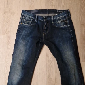 Replay Anbass - Snygga mörkblå jeans från Replay med klassisk femficksdesign och dragkedja. Jeansen har en stilren look med lätt slitna detaljer och en bekväm passform. Passar med typ vad som helst. Waist=30 Length=32 tänker mig 750, nypris 1700.