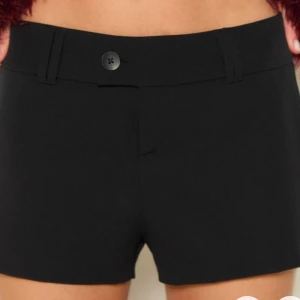Svarta shorts med knapp - Snygga svarta shorts med knapp och bälteshällor. Perfekta för en stilren look. Helt nya med prislapp på.