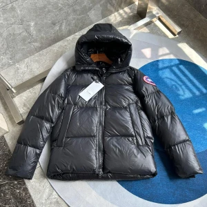 Svart dunjacka från Canada Goose - Säljer en svart dunjacka från Canada Goose med huva och dragkedja. Jackan har en klassisk pufferdesign och en logotyp på ärmen. Perfekt för kalla dagar.