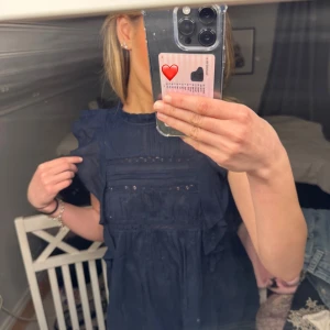 Mörkblå blus💙🤩 - Säljer en söt mörkblå blus med spetsdetaljer och volanger på axlarna. Blusen har en luftig passform och korta ärmar, perfekt för både vardag och festliga tillfällen. Knappt använd🥰