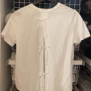 Vit t-shirt med knytning från ONLY - Säljer en vit t-shirt från ONLY med unik knytning på baksidan. Nyskick💗