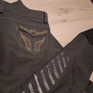 Animo ridbyxor (knöskodda) - Ett par Animo ridbyxor som är knäskodda. De är mörkgröna och har fina detaljerade fickor. De är i storlek I-42 D-36 (motsvarande stl 38). De är även strechiga längst ner vid benen. De ör lite noppriga uppe vid midjan men anars är de väldigt fina. De kostar 600 kr (nypris ca 2000kr). ✨️🐎 pris kan diskutersas