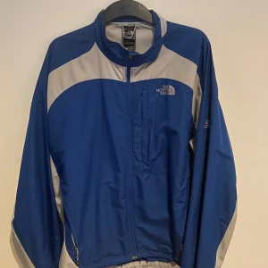 The North Face jacka - Säljer en blå och grå vindjacka från The North Face. 
