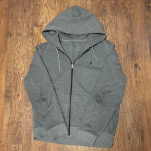 Grå hoodie från Ralph Lauren - Säljer en grå zipper från Ralph Lauren. Endast använd 3 gånger då det var fel storlek så in princip helt ny. Bara skriva om man har nån fråga eller fundering. 