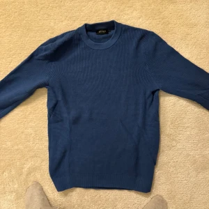 Blå stickad tröja från Riley - Snygg blå stickad tröja från Riley rund hals och långa ärmar. Perfekt för kyligare dagar och enkel att matcha med olika outfits. Storlek M. Mycket bra skick.