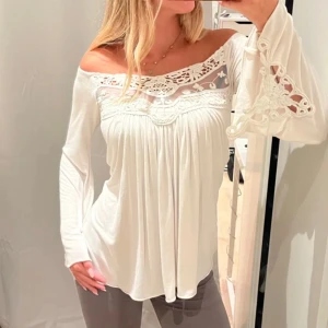Vit offshoulder topp 💕 - Säljer en vacker vit offshoulder topp från Sky med spetsdetaljer och vida ärmar. Toppen har en luftig passform och är perfekt för en stilren look. Passar bra till både jeans och kjol. Aldrig använt denna , köpte fen från plick!💕💕