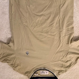 Beige t-shirt från penguin  - Säljer en stilren beige t-shirt från pinguin med en liten broderad logga på bröstet. T-shirten har korta ärmar och en klassisk passform. Perfekt för en avslappnad stil. Storlek M. Mycket bra skick