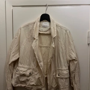 Beige jacka från Bershka - Säljer en kort beige jacka från Bershka. Jackan har långa ärmar och praktiska fickor framtill💗Perfekt till våren!