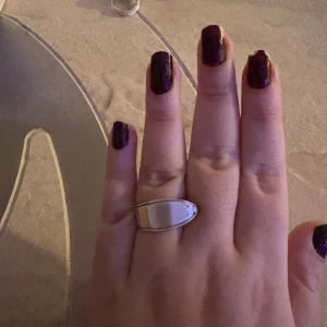 Silverfärgad ring i unik design gjord av sked - Säljer en stilren och elegant silverfärgad ring med en unik, böjd design. Perfekt för att ge en modern touch till din stil. Passar både till vardag och speciella tillfällen.