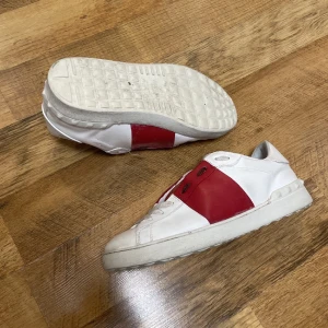 Valentino Garavani Skor  - Tja säljer ett par Valentino skor i färgen vit och röd i storlek 42, dem är i fint skick, dem är sparsamt använda, skriv om ni har några frågor eller funderingar OBS!!!! Priset är hugget i sten!!!!