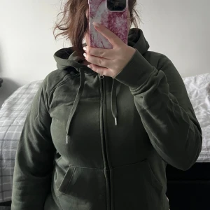 Grön hoodie med dragkedja - Säljer en grön hoodie med dragkedja och huva. Den har långa ärmar och en bekväm passform. Den är i mycket bra skick och är köpt från Cubus.  
