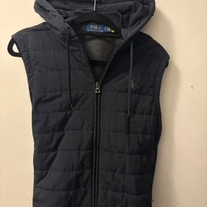 Mörkblå väst från Polo Ralph Lauren - Snygg mörkblå väst från Polo Ralph Lauren. Säljer för inte så mycket användning av den. Köpt för 3200kr på polo Ralph Lauren’s sida. Säljer för 1899kr. Pris kan diskuteras.😊