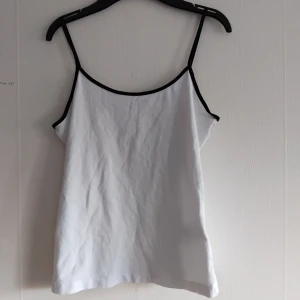 Vit linnetopp från H&M - Ett vitt linne med svarta axelband från H&M. Aldrig använd