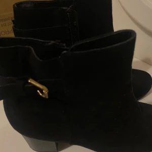 Svarta mocka boots med klack - Snygga svarta boots i mocka med klack och dragkedja på sidan. De har en dekorativ guldfärgad spänne som ger en extra touch. Perfekta för höst och vinter.🤍😍