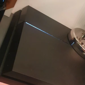 Svart spelkonsol med två handkontroller - Säljer en svart spelkonsol med två matchande handkontroller. Konsolen har en elegant design med en lysande linje på ovansidan. Handkontrollerna har en unik design med vita detaljer och lysande ljus. Perfekt för spelkvällar med vänner! Superbra kvalité båda kontrollerna funkar utmärkt! Ingen stickdrift! Konsolen låter ingenting priset kan diskuteras