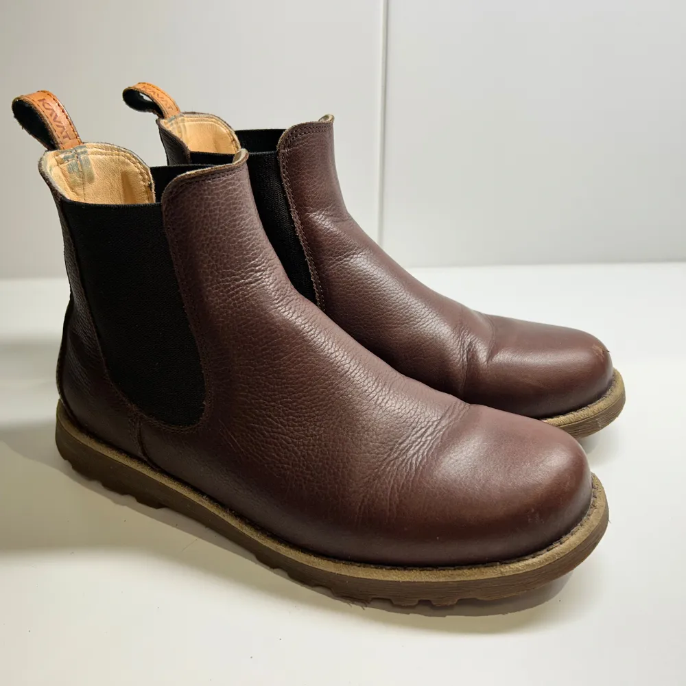 Säljer ett par snygga bruna Chelsea boots från Kavat i skinn, storlek 40. De har en robust sula och är perfekta för höst och vinter. Bootsens elastiska sidor gör dem lätta att ta på och av. De är i bra skick med lite slitage på tån, men annars välbevarade. . Skor.