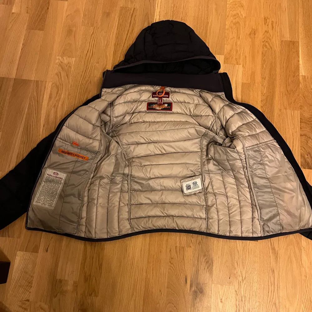 Säljer en marinblå dunjacka från Parajumpers i storlek S. Jackan är superlätt och har en huva samt dragkedja framtill. Perfekt för kyliga dagar och har en snygg patch på ärmen. Den är i mycket bra skick. . Jackor.