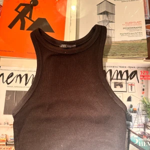 Svart ribbad linnetopp från Zara - Snygg svart ribbad linnetopp från Zara i ett stretchigt material. Perfekt för både vardag och fest. Toppen har en enkel och stilren design med rund halsringning.
