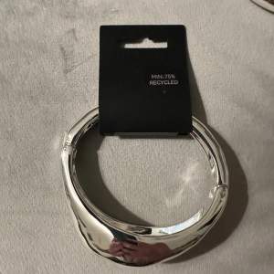 Snyggt och stilrent armband i silverfärg från Pilgrim. Gjort av minst 75% återvunnet material, vilket gör det både trendigt och miljövänligt. Perfekt för att ge en elegant touch till vilken outfit som helst. Nytt och oanvänt, redo att bäras till fest eller vardag. Produktvärd 549kr