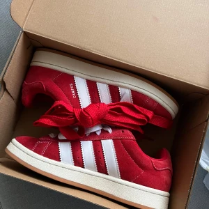 Röda Adidas Campus 00’s sneakers - Säljer ett par snygga röda Adidas Campus 00’s sneakers. Skorna är i mycket bra skick och använda fåtal gånger! Storlek 40. Röda snören och originalkartong medföljer. Så snygga och världens skönaste skor men har tyvärr ingen användning av dem. Köpta på ASOS för 1349kr, mitt pris: 1150kr, riktigt kap! Priset går att diskuteras vid snabb affär. ❤️ 