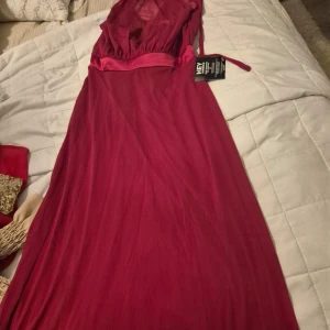 Lång vinröd klänning  - Helt ny lång röd klänning. Jättefin.