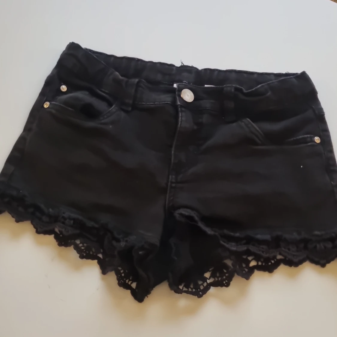 Svarta shorts som är lågmidjade med spetsdetaljer från Kappahl