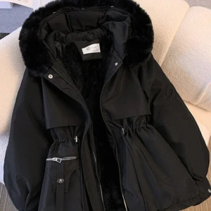 Svart parkajacka - Säljer en snygg svart parkajacka med päls på huvan. Jackan har dragkedja och knappar framtill samt justerbar midja för perfekt passform. Perfekt för kyliga höst- och vinterdagar. Den är i mycket bra skick och supermysig att ha på sig! Helt oanvänd. Den passar till storlek S och Xs